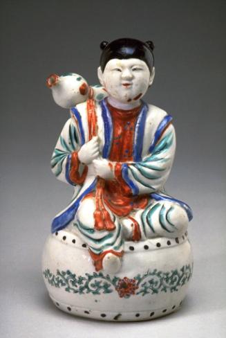 Figure of a boy seated atop a drum
