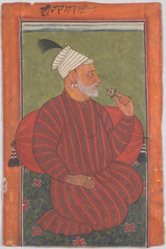 Seated man smelling a flower